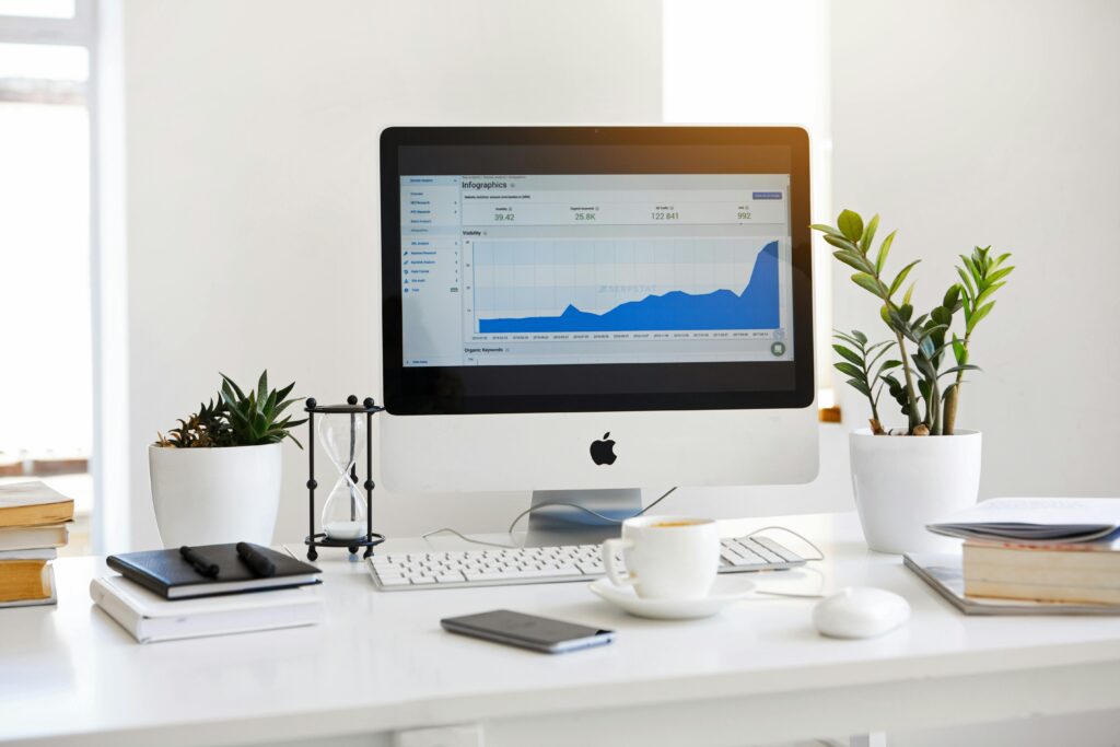 A clean, contemporary workspace featuring a desktop with analytics on the screen and plants for a fresh look. Digital marketing strategist