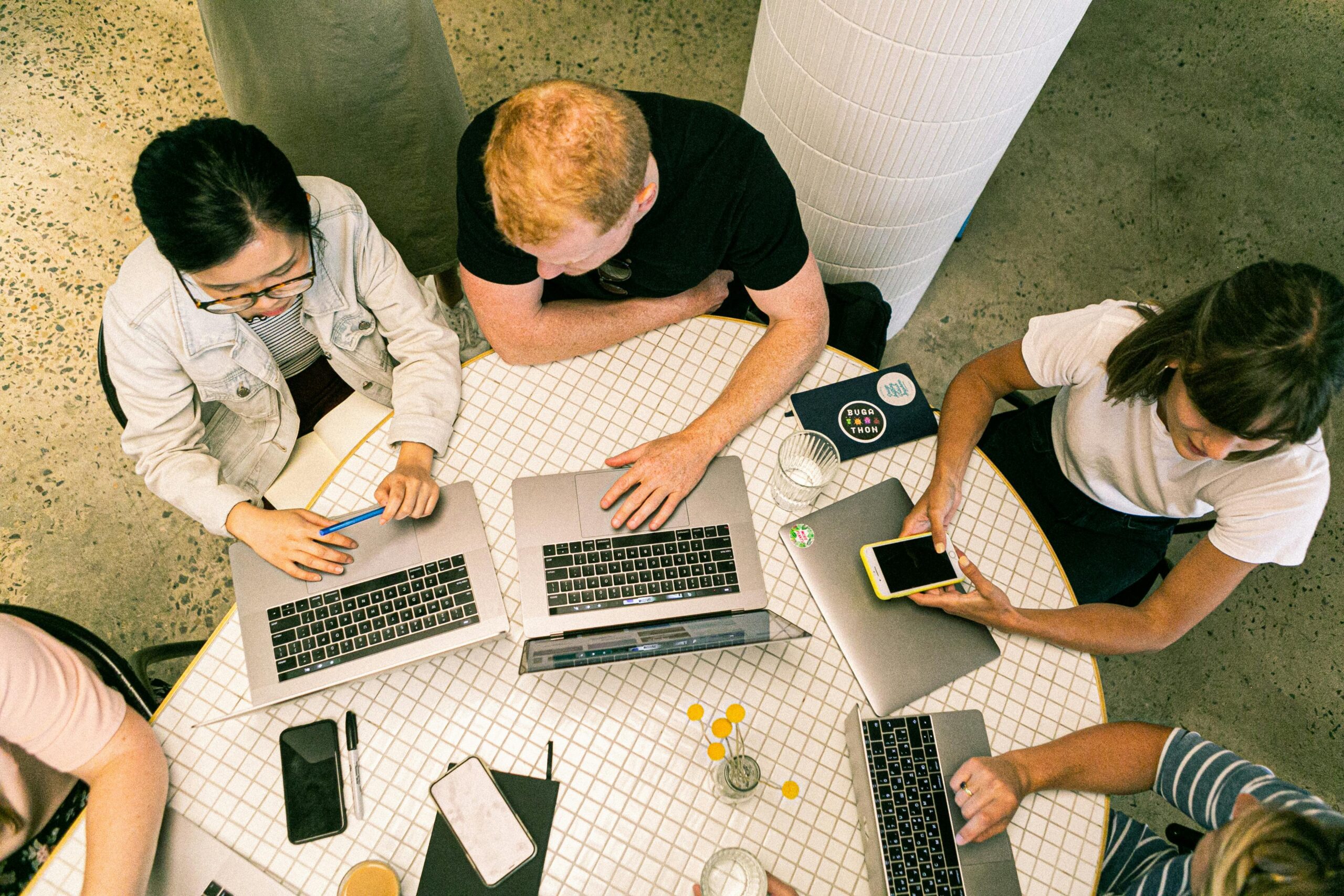 Top view of diverse team collaboratively working in a modern office setting. Microenvironment vs. Macroenvironment in Marketing