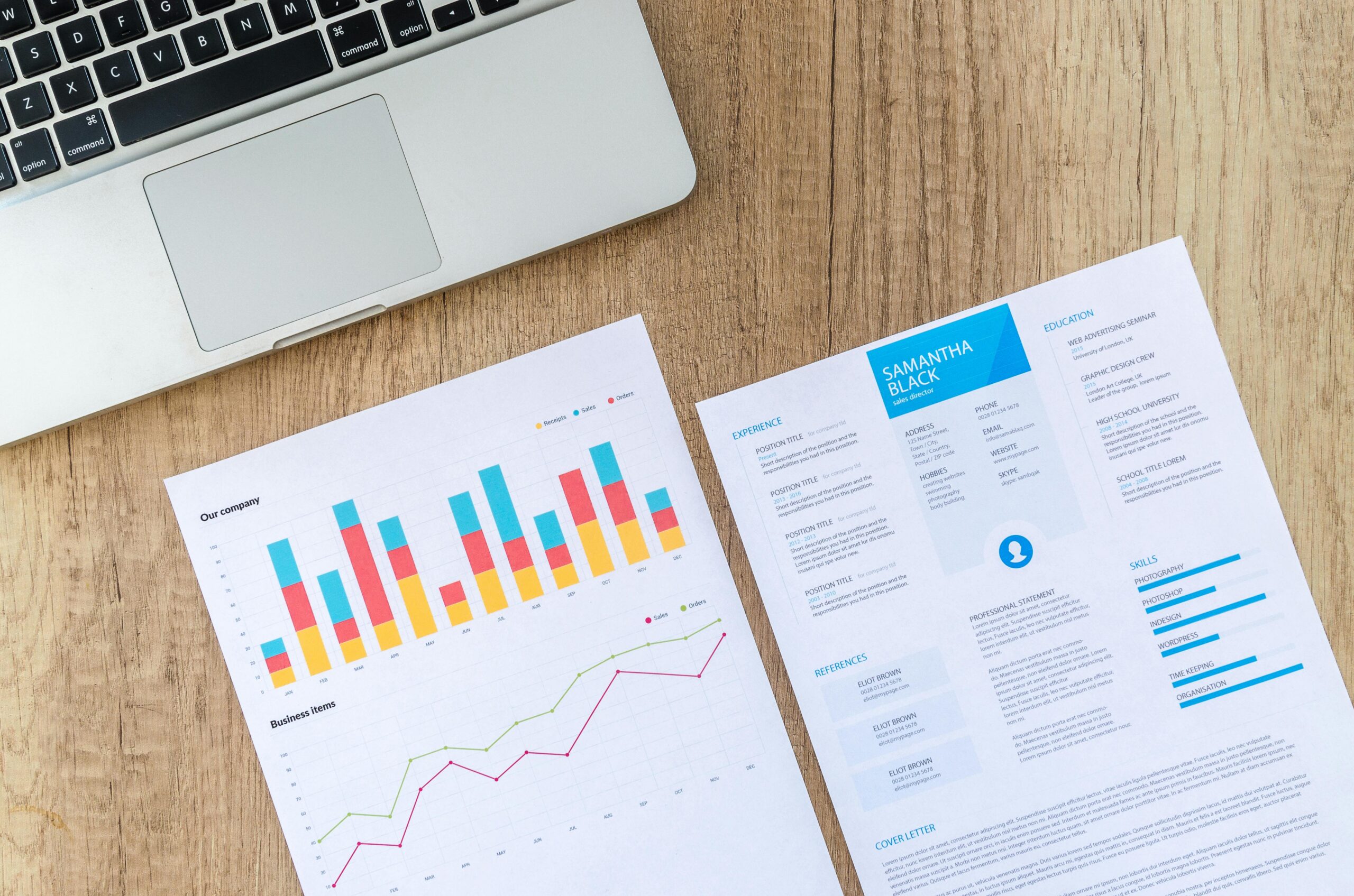 Top view of a laptop, charts, and resume on a wooden desk, showcasing business analysis and job application.Master 2025’s Digital Marketing Strategy Now