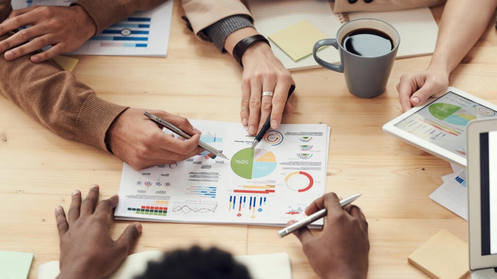 Colleagues discussing data and strategy in an office meeting. What is Marketing Project Planning? Complete Guide for 2025